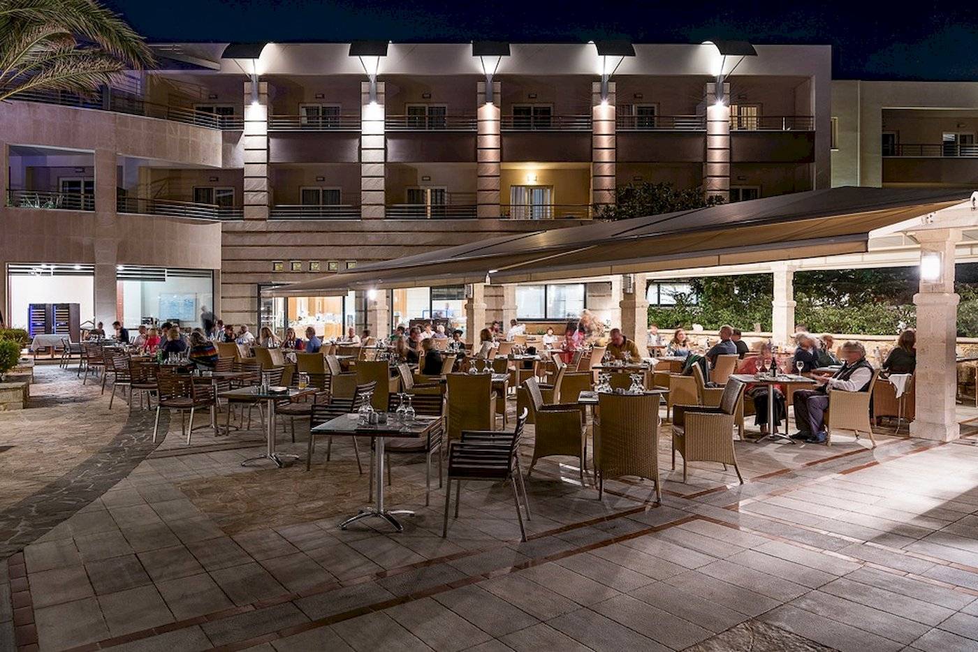 Ein Hotelrestaurant bei Nacht mit Gästen, die an Tischen sitzen und essen.