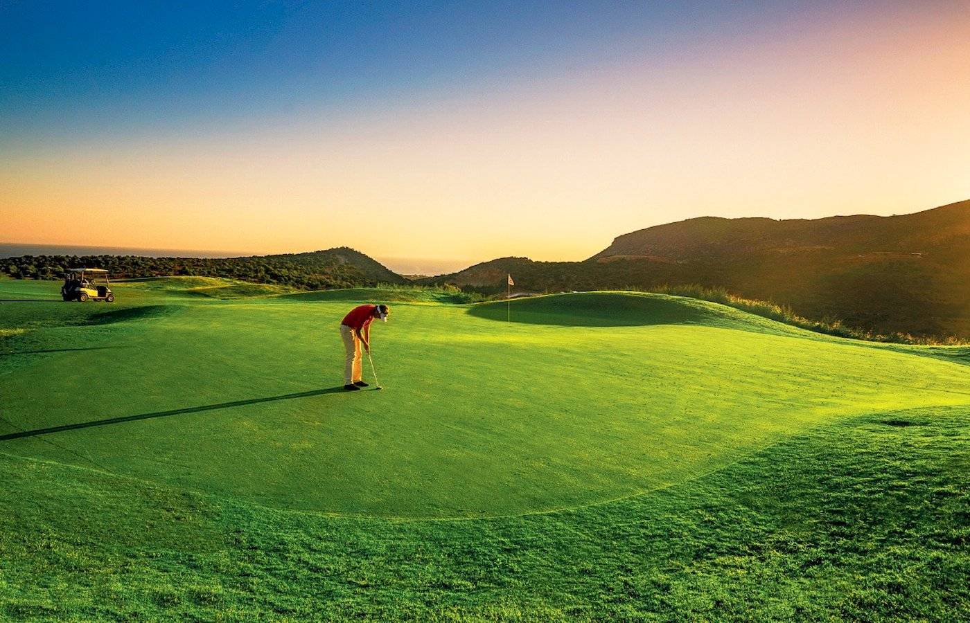 Golfer auf dem Golfplatz des Grecotel Meli Palace während des Sonnenuntergangs.