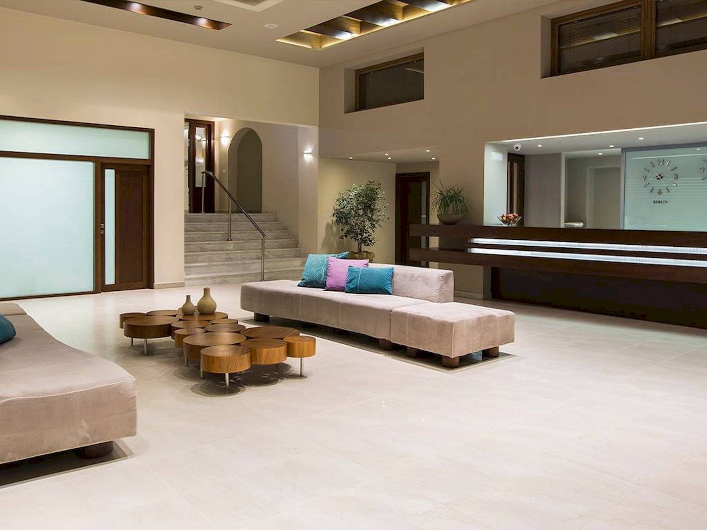 Empfangsbereich des Chrissi Amoudia Hotels mit Couchgarnitur und Treppen.