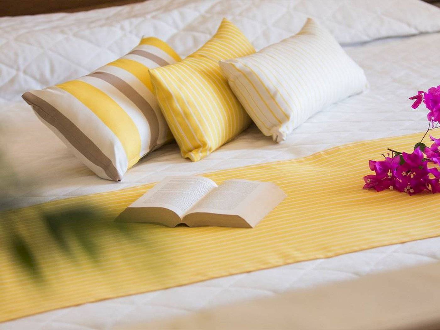 Hotelbett mit Kissen und Büchern von Chrissi Amoudia