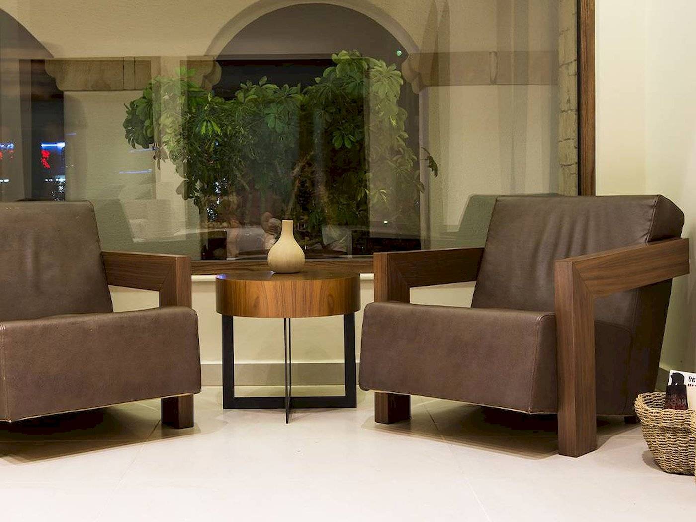 Loungebereich im Chrissi Amoudia Hotel mit zwei Ledersesseln und einem Tisch.