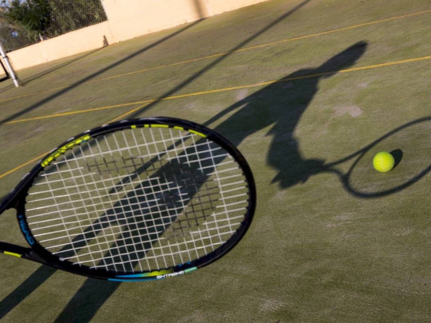 Tennisschläger mit Tennisball auf einem Tennisplatz.