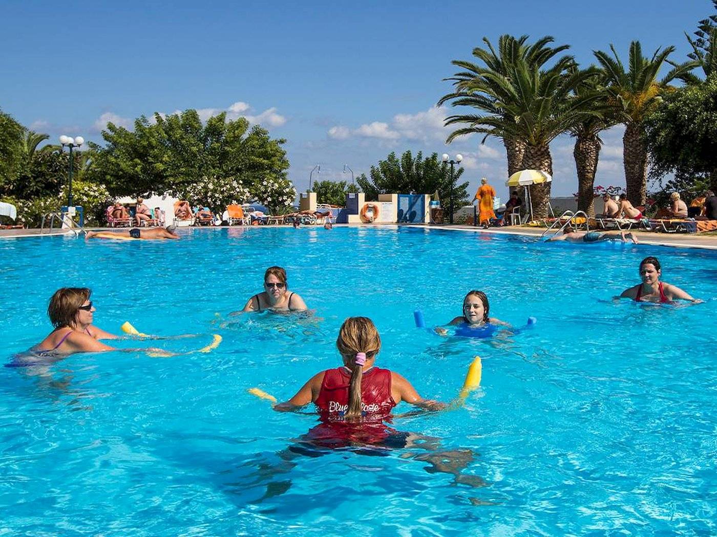 Gruppe von Frauen, die Wassergymnastik im Pool des Chrissi Amoudia Hotels machen.