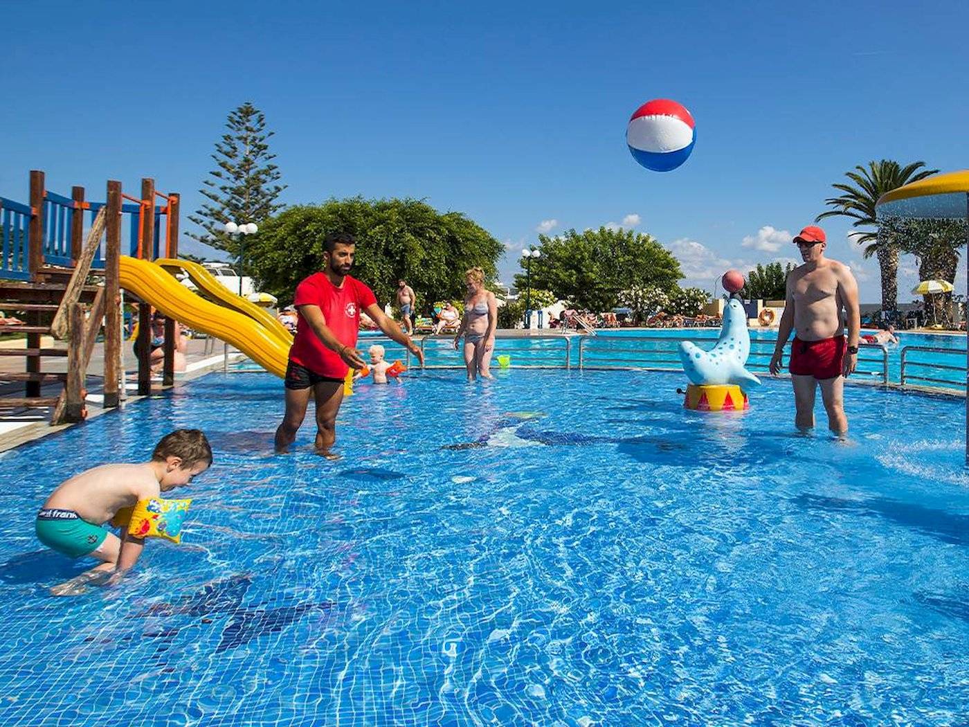 Kinderpool im Chrissi Amoudia Hotel mit Animationsteam und Gästen, die Spaß haben.