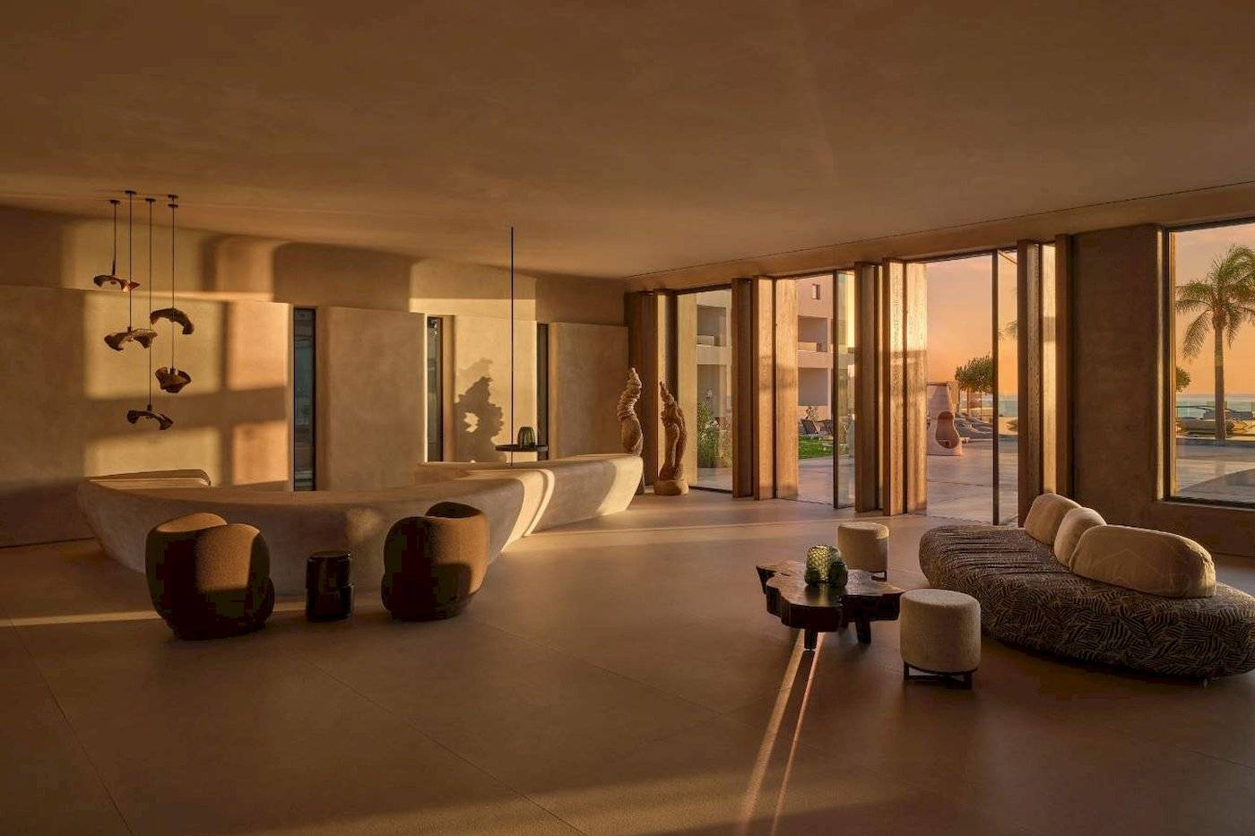 Minos Palast Hotel & Suites Innenbereich mit Möbeln, großem Fenster und Meerblick