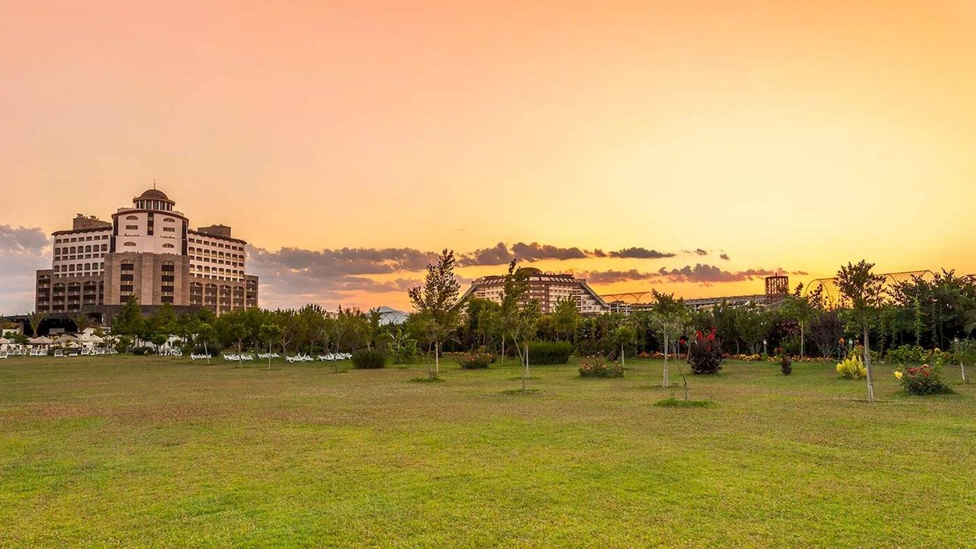 Melas Lara Hotel bei Sonnenuntergang mit Gebäuden und Rasen