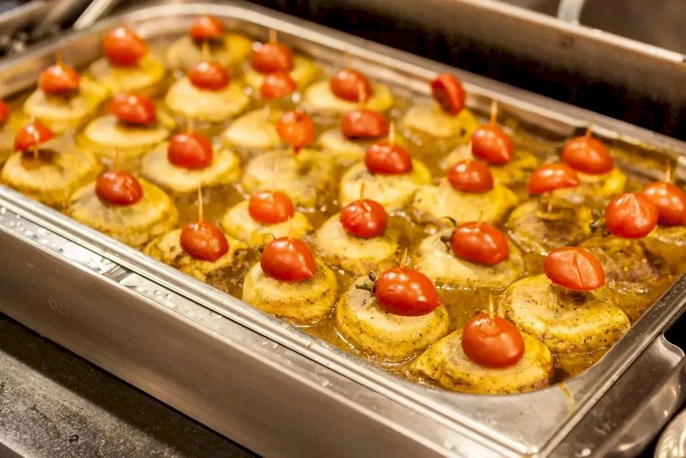 Ein Tablett mit gebackenen Kartoffeln, die mit Tomaten und Essiggurken auf Spießen serviert werden, im Melas Lara Hotel.