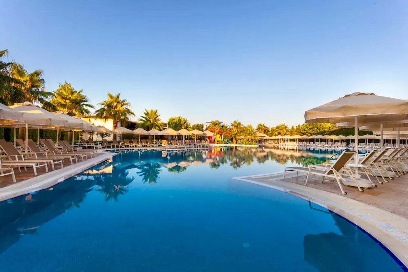 Außenpool mit Liegestühlen und Sonnenschirmen im Melas Lara Hotel