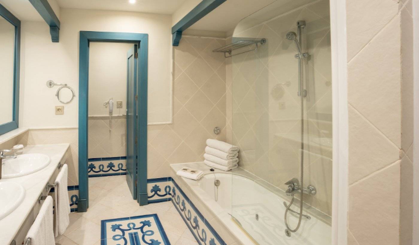 Badezimmer im LIVVO Volcan Lanzarote Hotel mit Badewanne und blauen Fliesen.