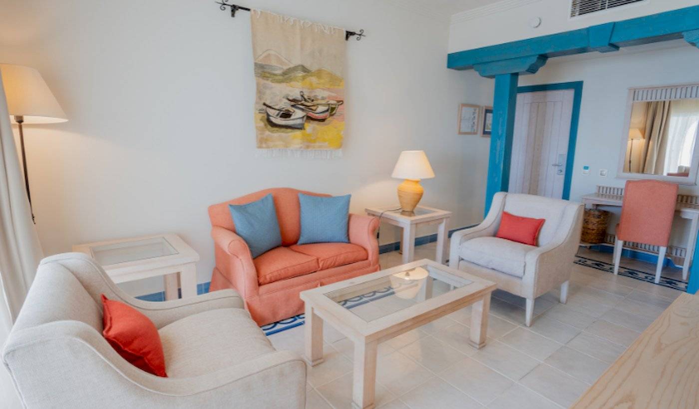 Wohnzimmer im LIVVO Volcan Lanzarote Hotel mit zwei Sofas, einem Tisch, einer Lampe und einer Wanddekoration.