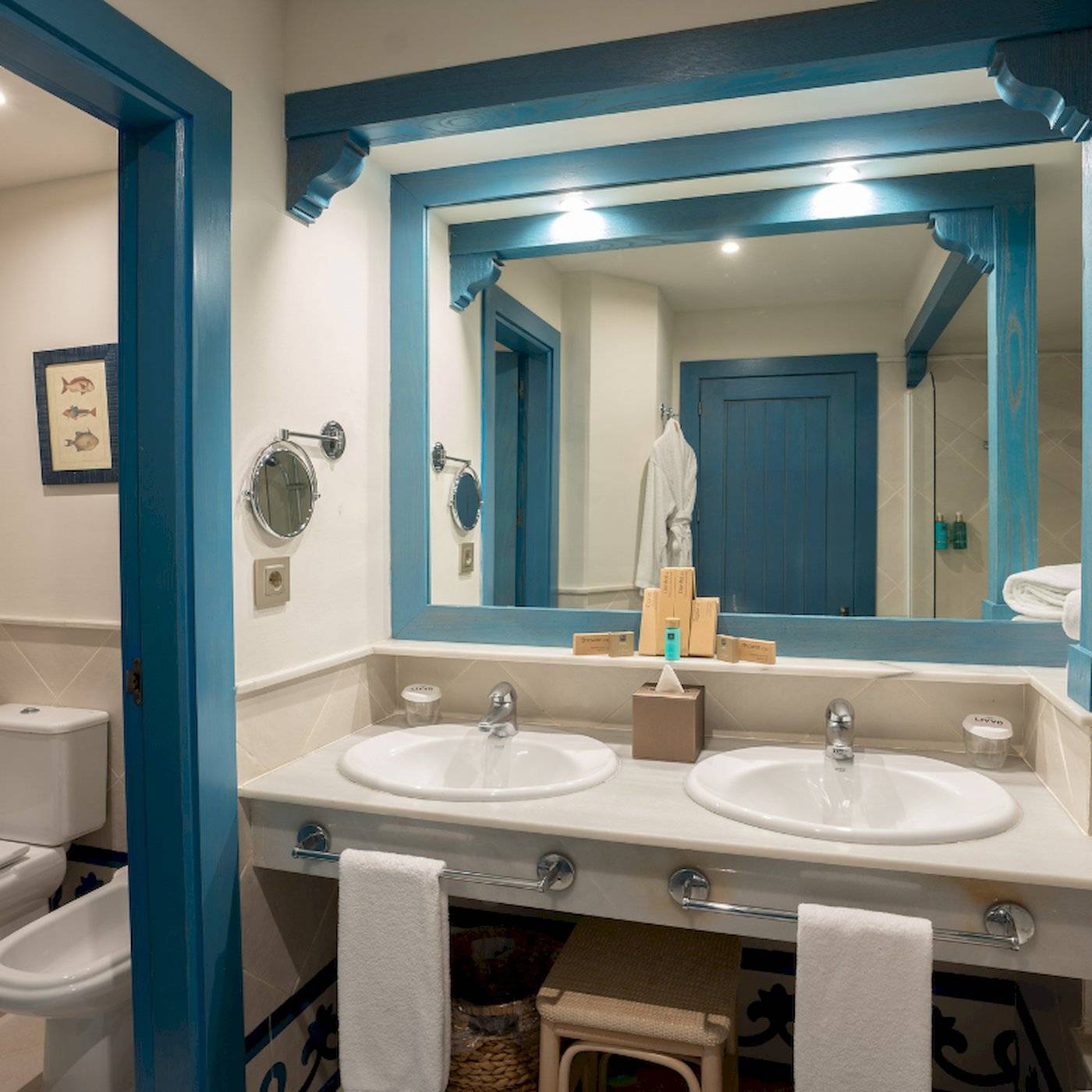 Badezimmer im LIVVO Volcan Lanzarote Hotel mit blauen Akzenten und einem Spiegel.