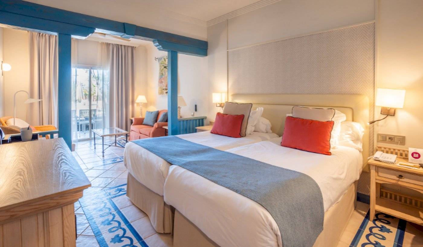 Doppelzimmer im LIVVO Volcan Lanzarote mit zwei Betten, einem Balkon und modernen Möbeln.