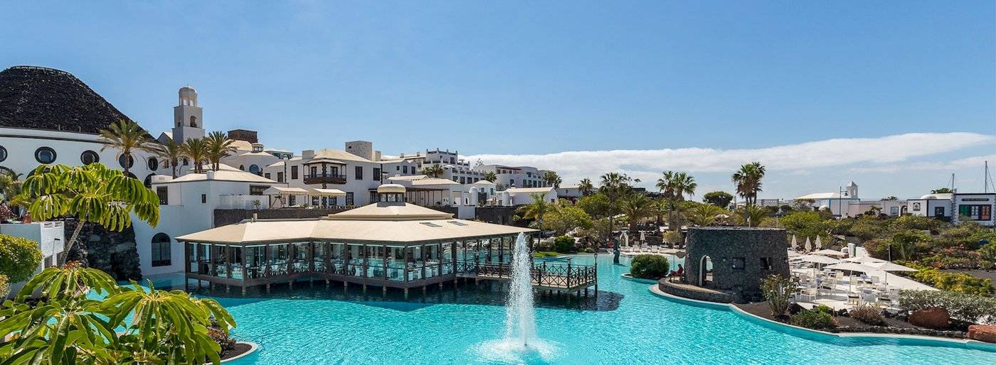 Livvo Volcan Lanzarote Hotel mit Pool und Gebäuden im Hintergrund