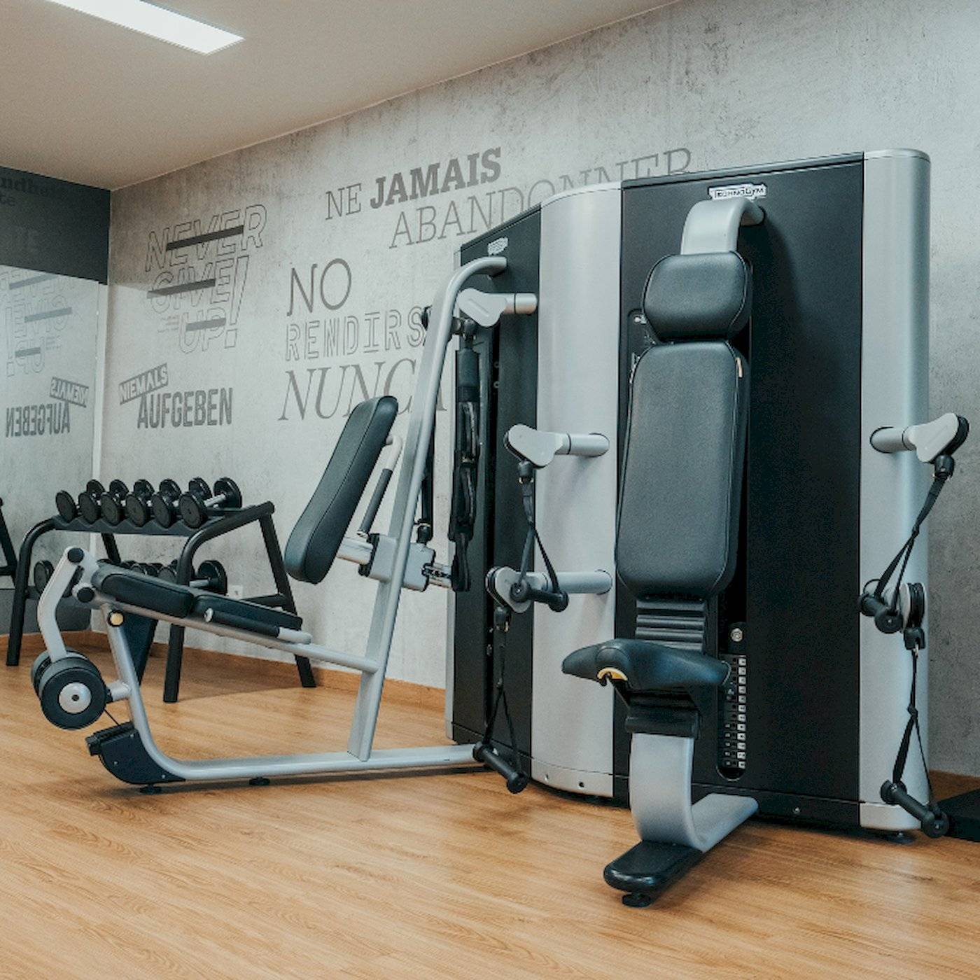 Fitnessstudio im LIVVO Volcan Lanzarote Hotel mit Trainingsgeräten und einer Wand mit Texten.