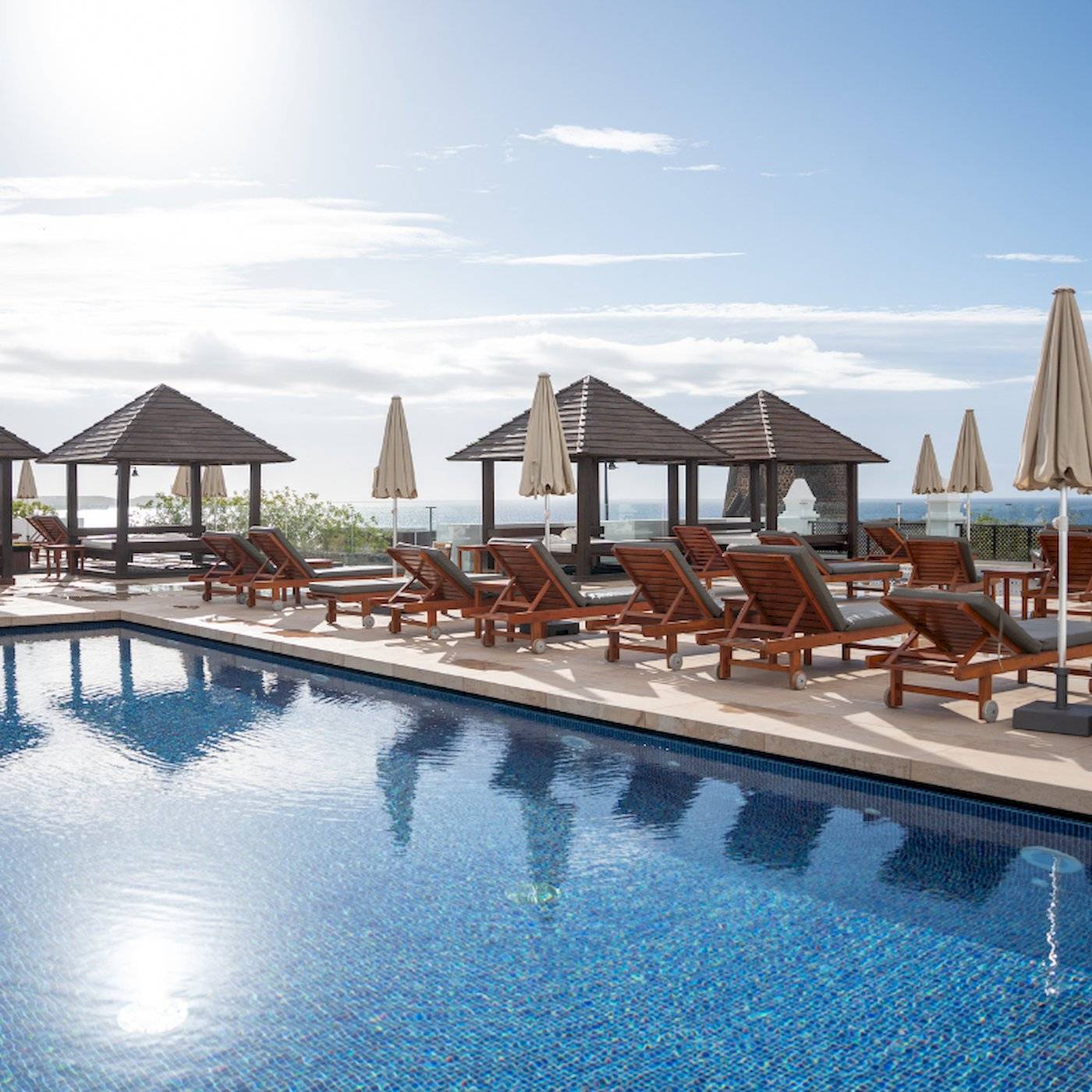 Pool-Terrasse des LIVVO Volcan Lanzarote Hotels mit Sonnenliegen und Schirmen