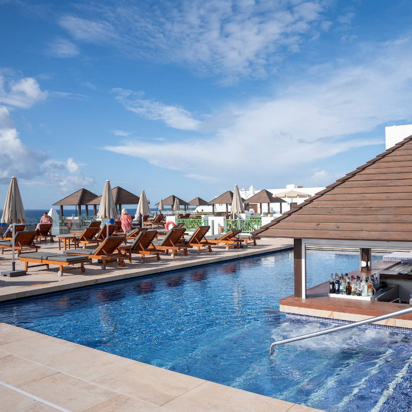 Poolbereich des LIVVO Volcan Lanzarote Hotels mit Liegen und Schirmen