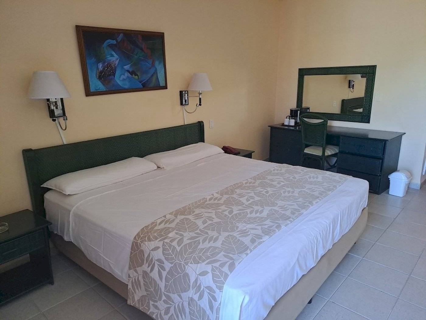 Hotelzimmer im Muthu Playa Varadero mit Doppelbett, Nachttischen und Dekor.