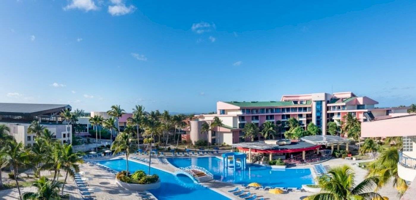 Außenbereich des Muthu Playa Varadero Hotels mit Swimmingpool, Sonnenliegen und Gebäuden