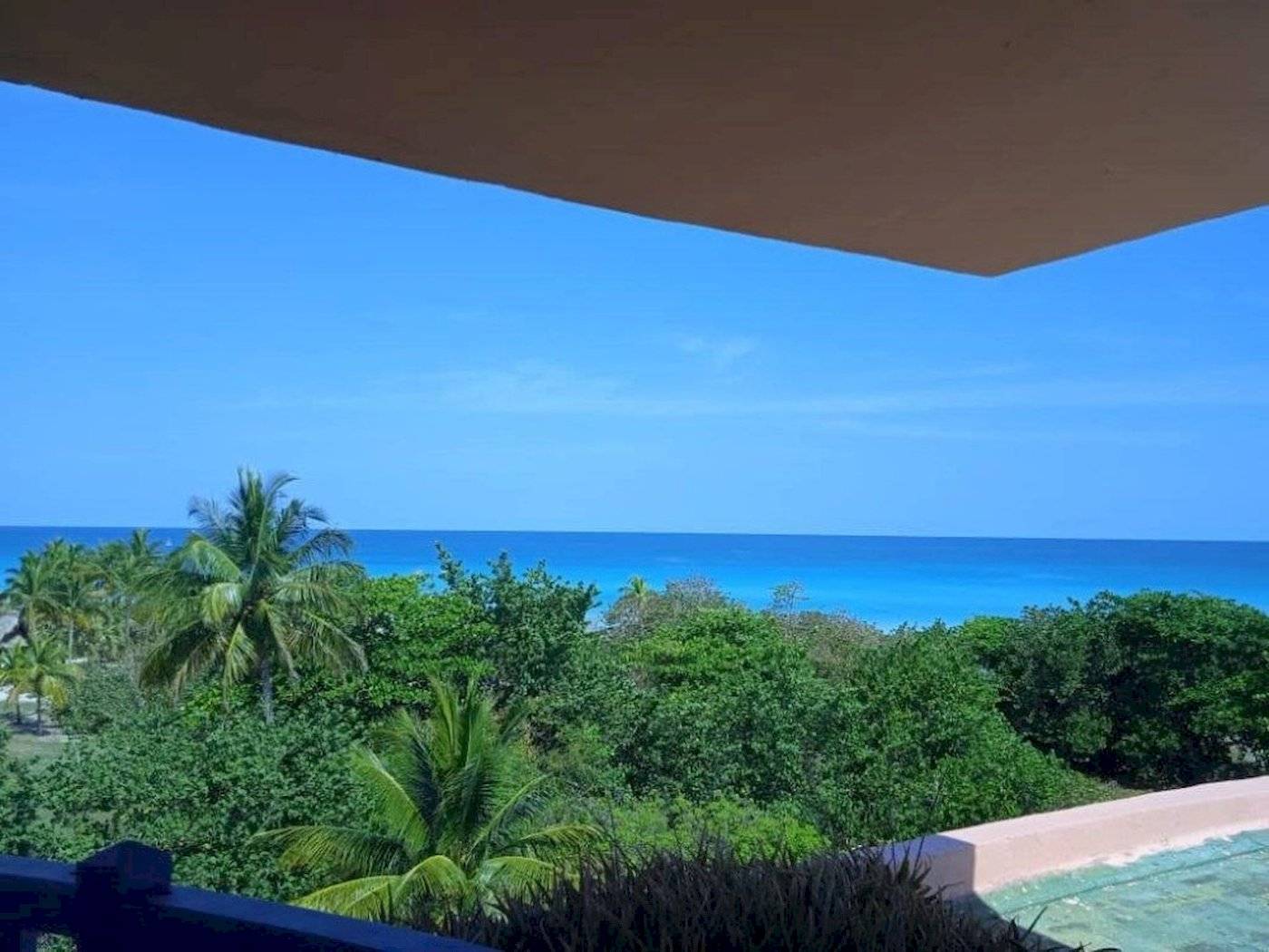 Aussicht auf den Ozean vom Muthu Playa Varadero Hotel aus mit blauem Himmel und grüner Vegetation.