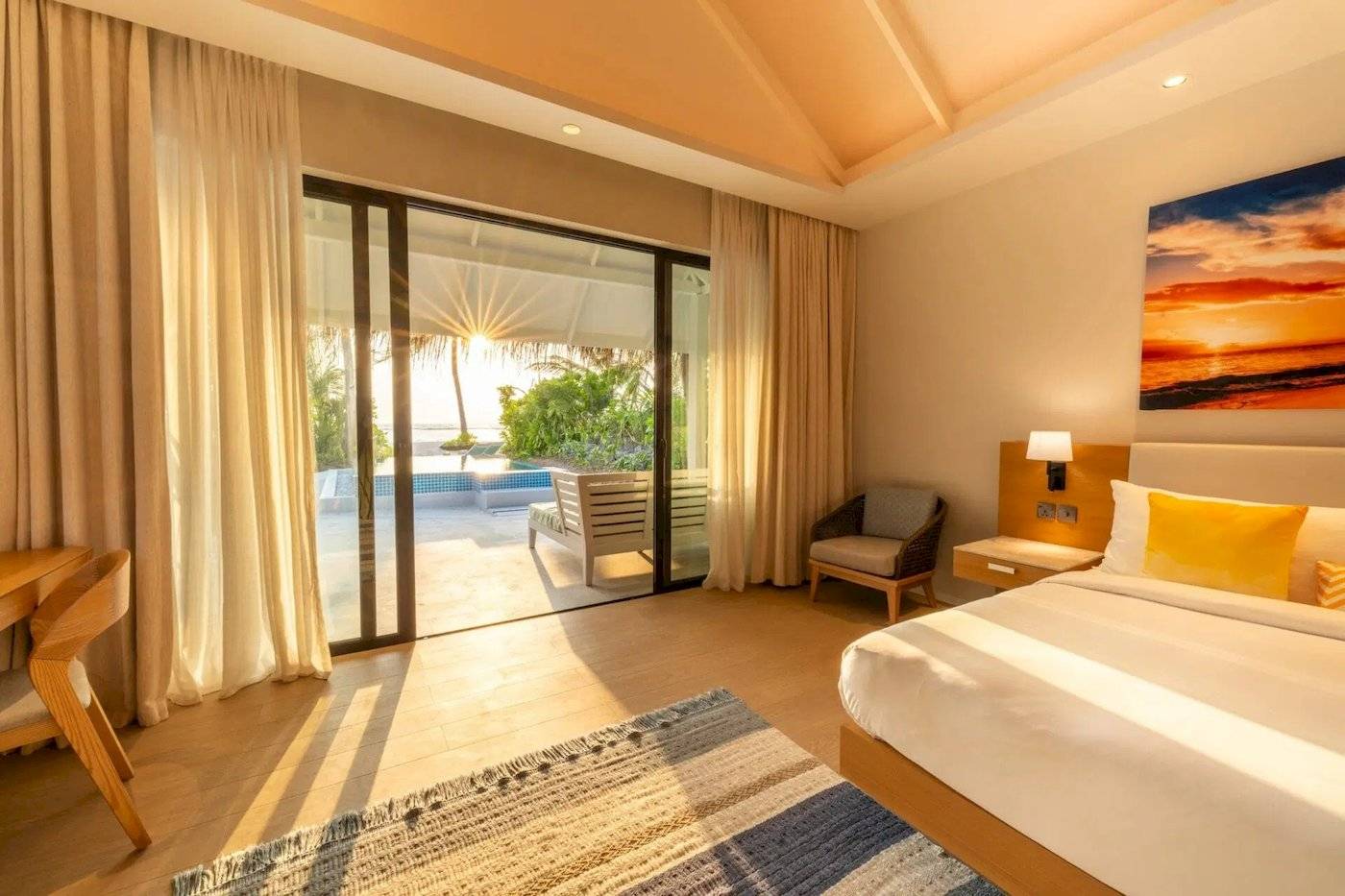 Suite-Zimmer im Nova Maldives Hotel mit Aussicht auf einen Pool und Meer.