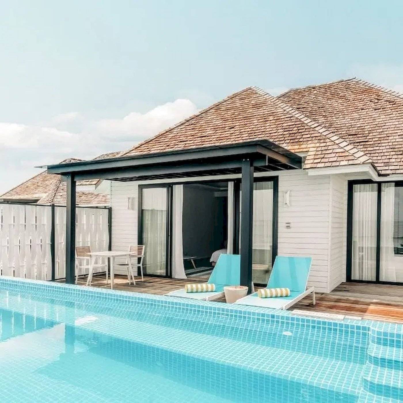 Außenbereich des Nova Maldives Hotels mit Pool und Lounge-Bereich.