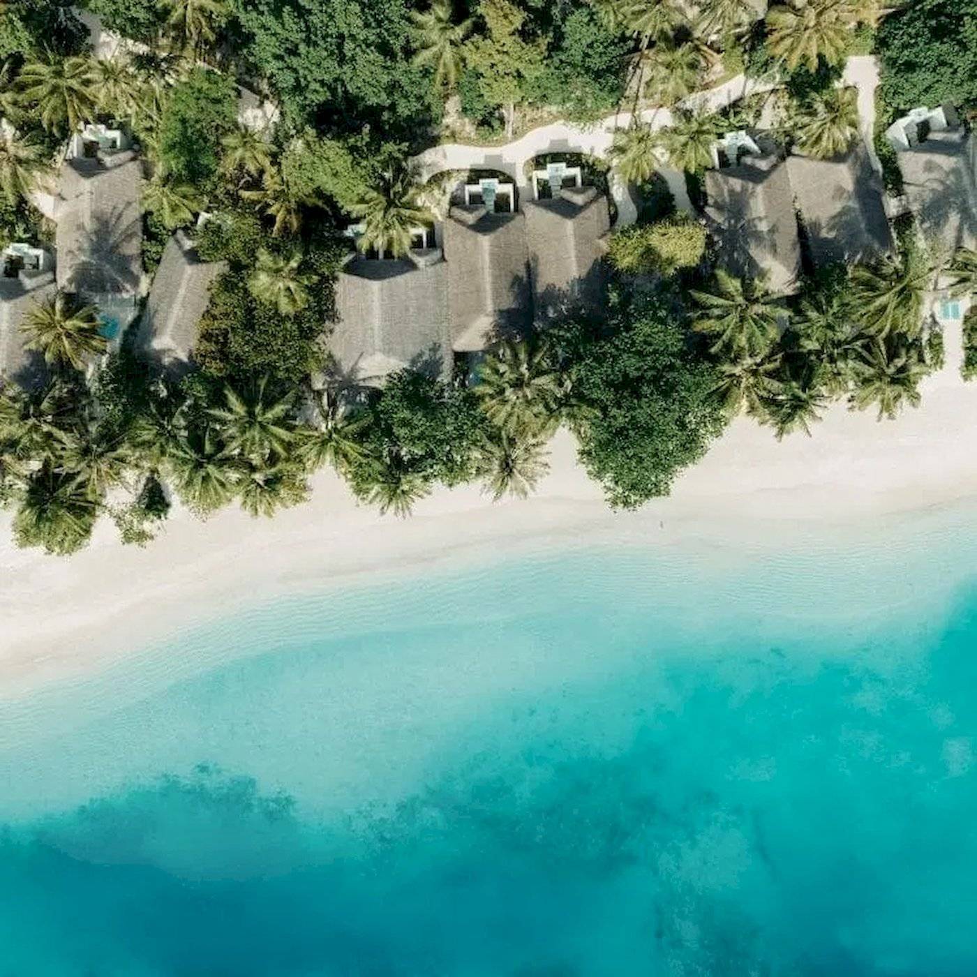 Obersflächlicher Blick auf das Nova Maldives Hotel mit weißen Stränden und blauem Wasser.