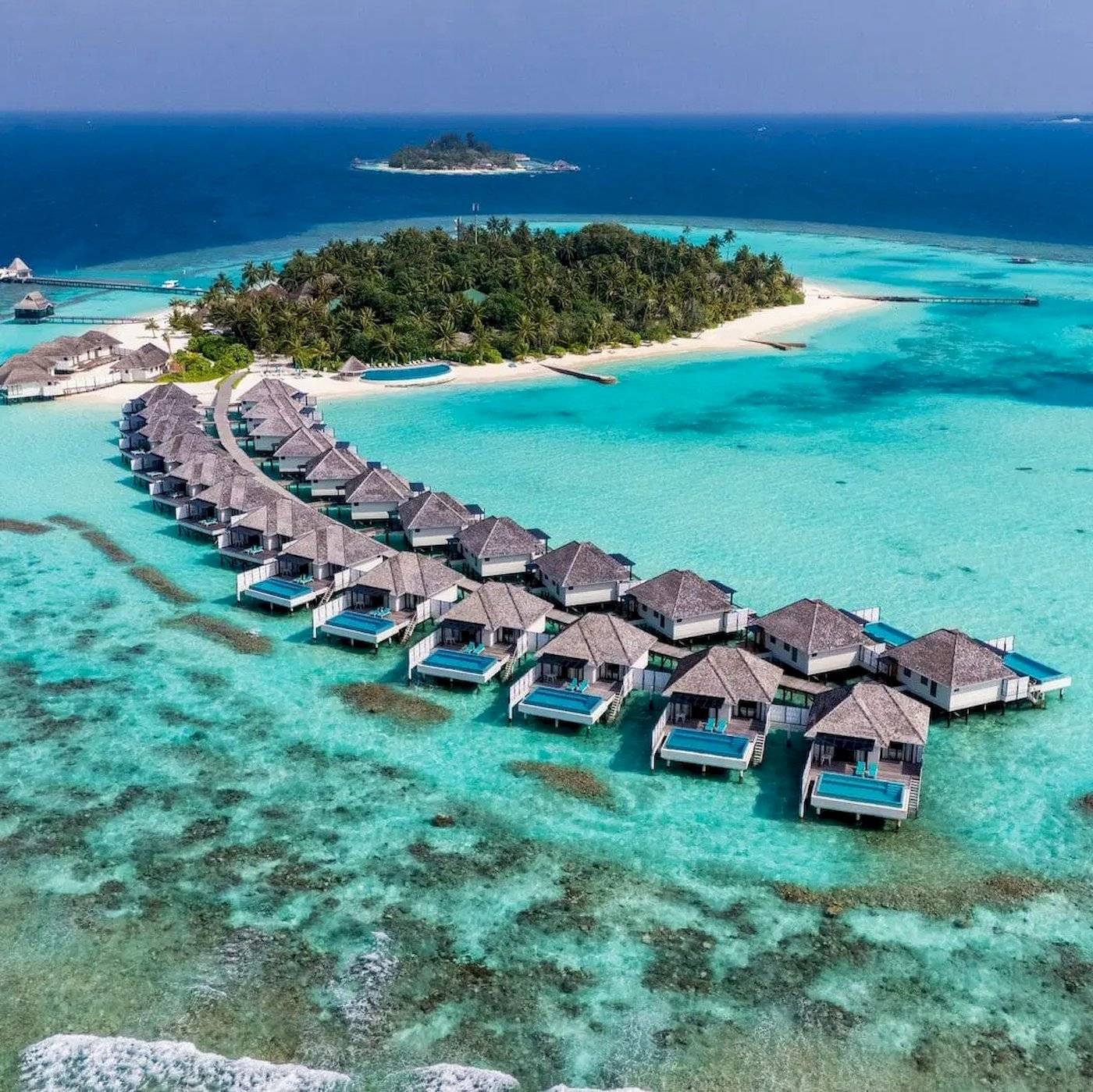 Luftaufnahme des Nova Maldives Resorts mit Wasservillen und türkisfarbenem Ozean