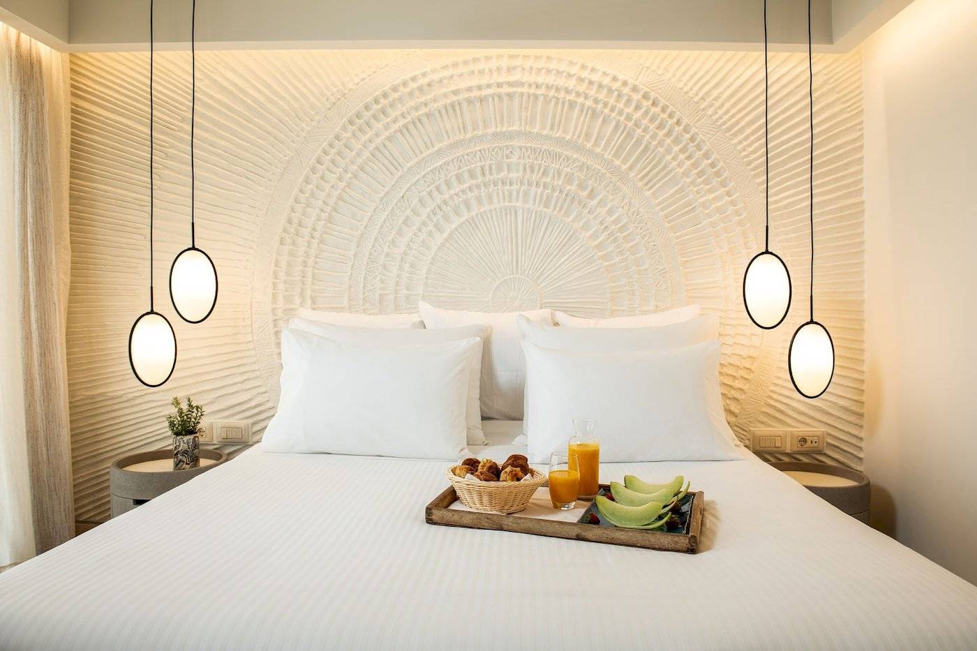 Fruehstueckskorb mit Obst auf einem Bett im Mitsis Selection Rinela Hotel.