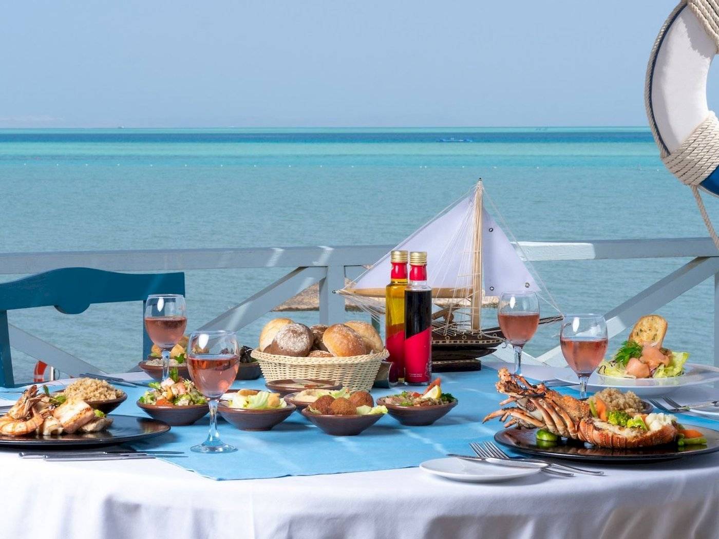 Meerblick-Tisch im Mövenpick Resort & Spa El Gouna mit vielen Gerichten, Gläsern und Dekoration.