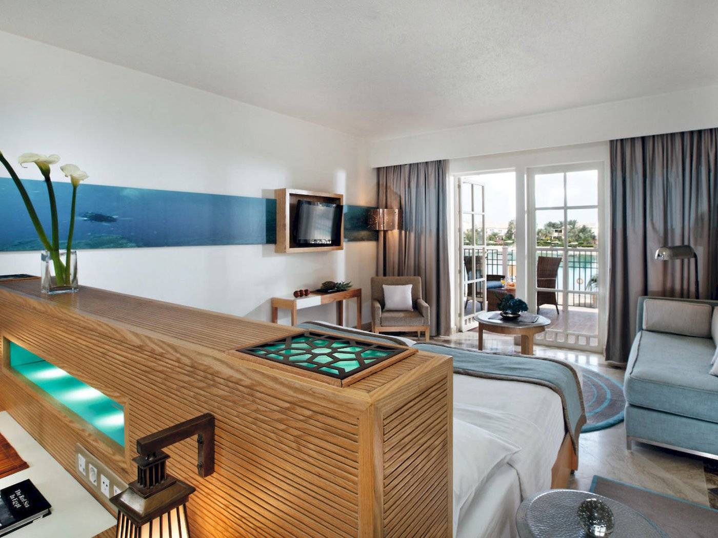 Innenansicht eines Hotelzimmers im Mövenpick Resort & Spa El Gouna mit Bett, Sofa und Meerblick