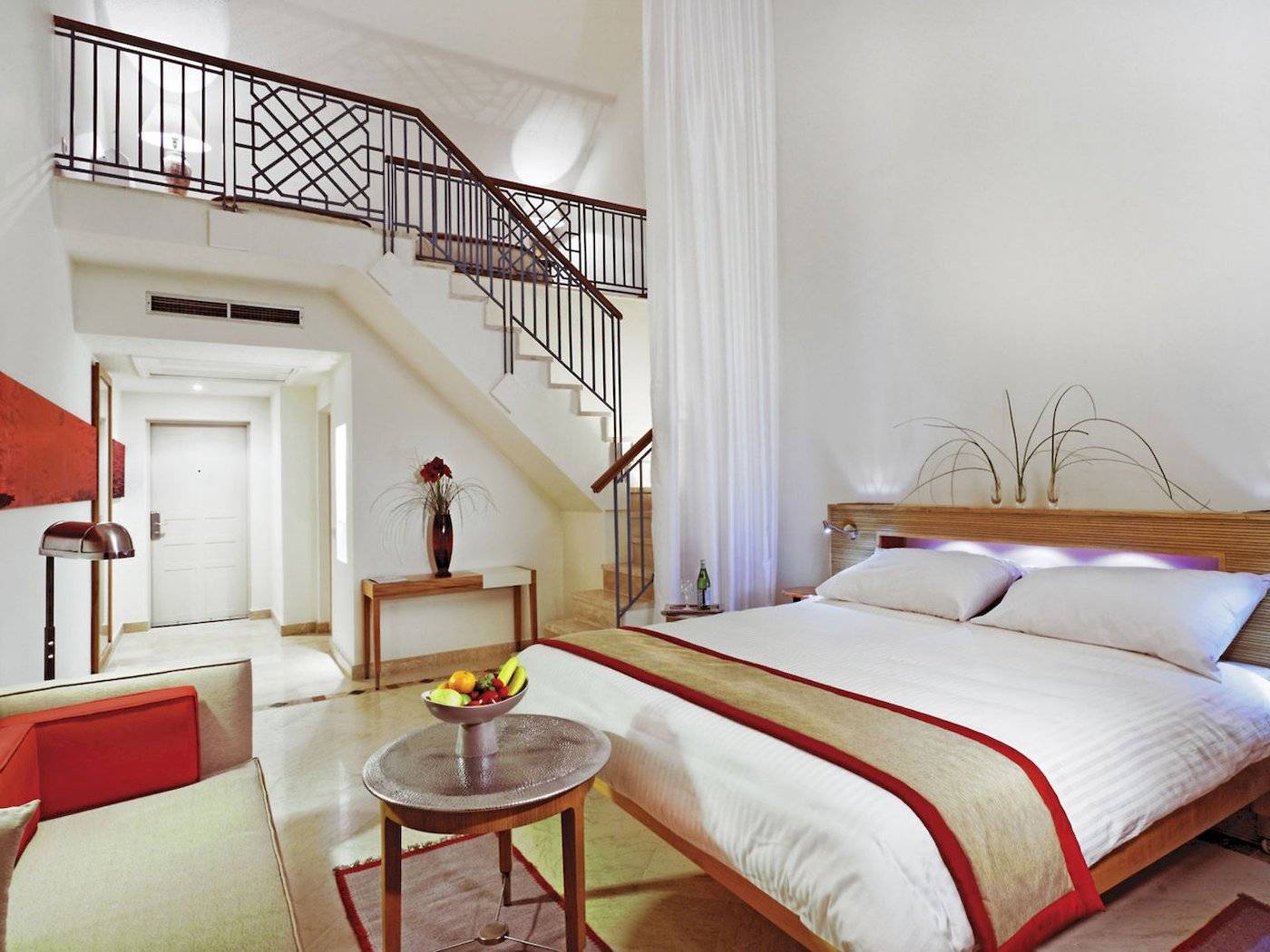 Interieur des Moevenpick Resort & Spa El Gouna mit einem Bett, Früchteschale und Treppe