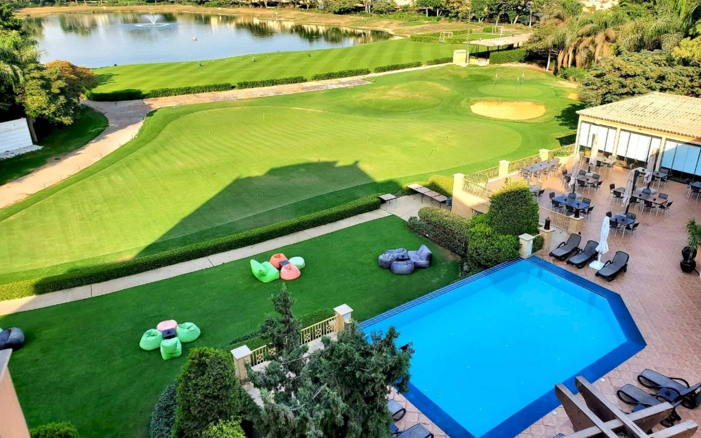 Luftaufnahme des Stella Gardens Resort & Spa Golfplatzes mit Außenbereich, Pool und Sonnenliegen.