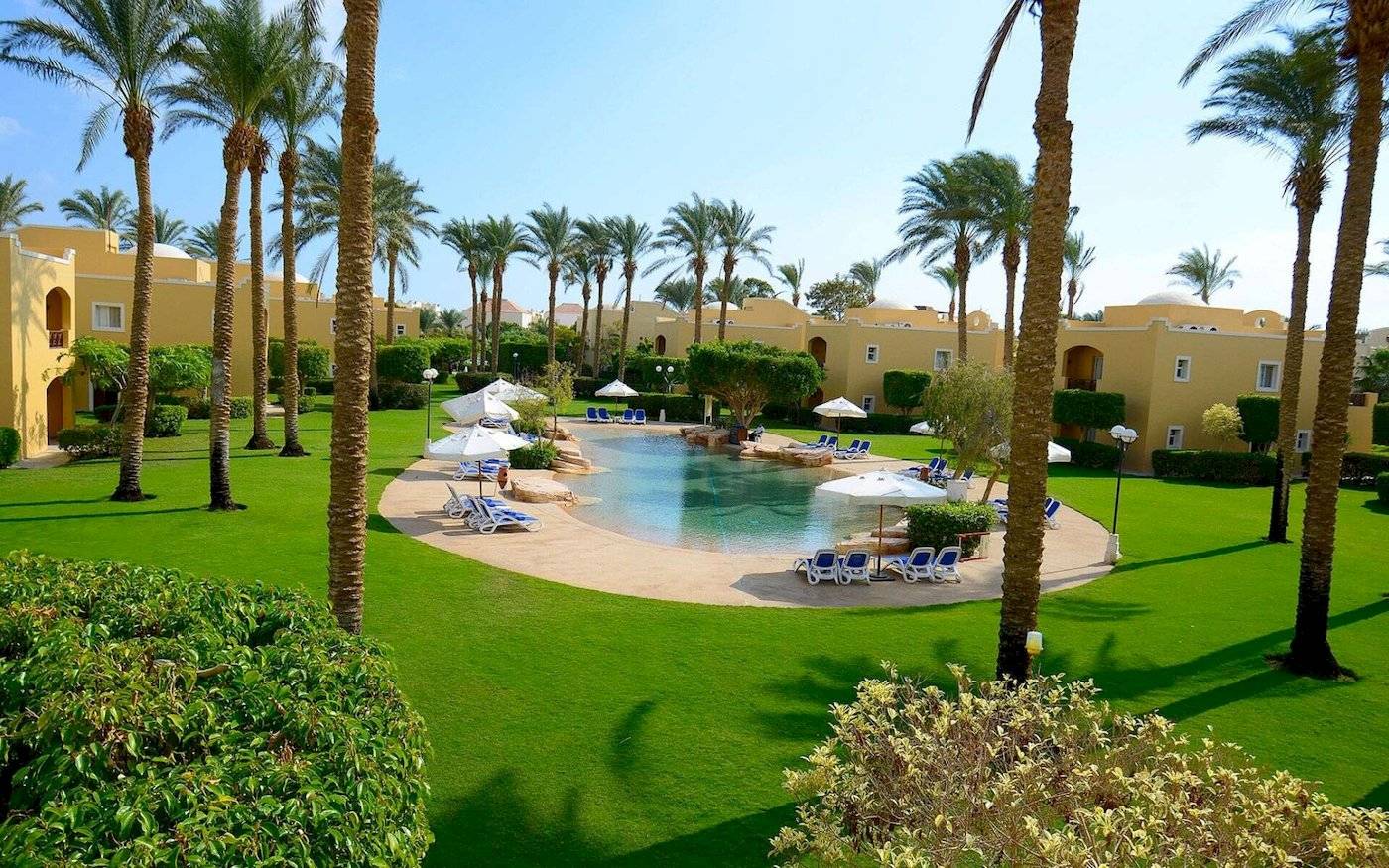 Luftaufnahme des Stella Gardens Resort & Spa Poolbereichs mit Palmen und Liegestühlen
