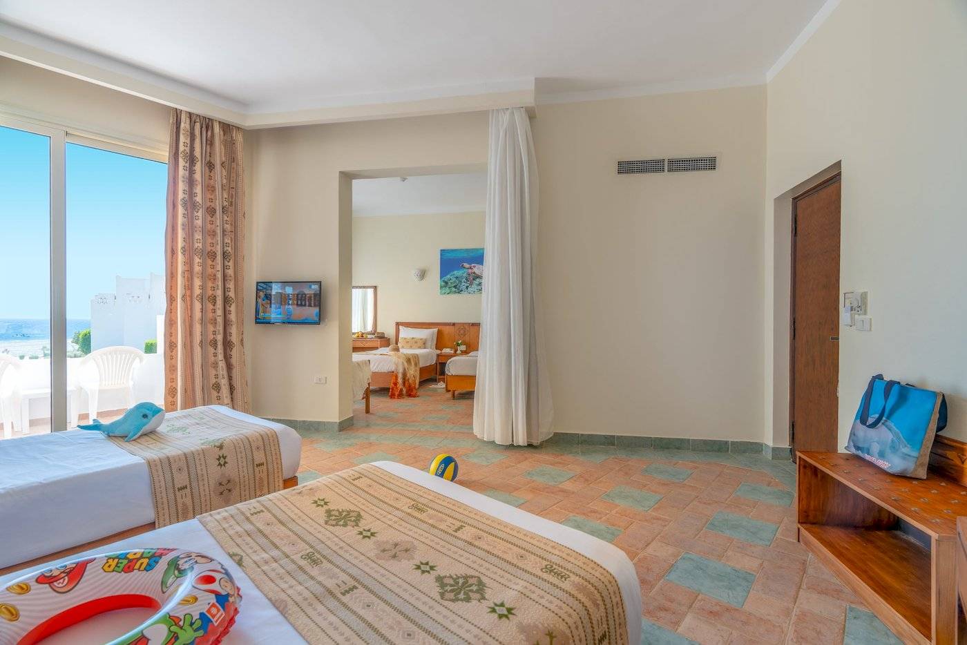 Zimmer im Three Corners Equinox Beach Resort mit zwei Betten, Fernseher und Meerblick.
