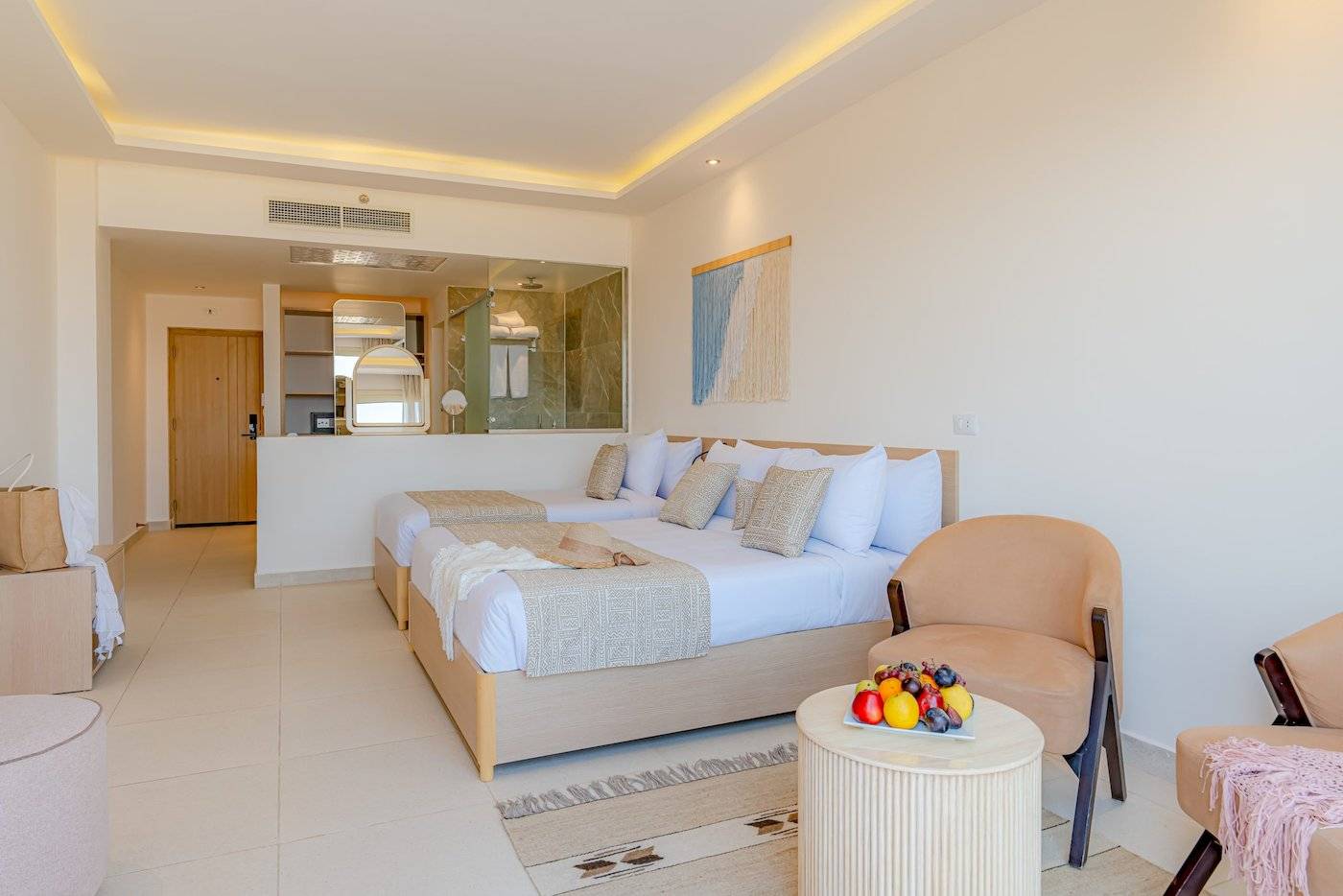 Doppelzimmer im Three Corners Equinox Beach Resort mit zwei Betten und Obsttablett
