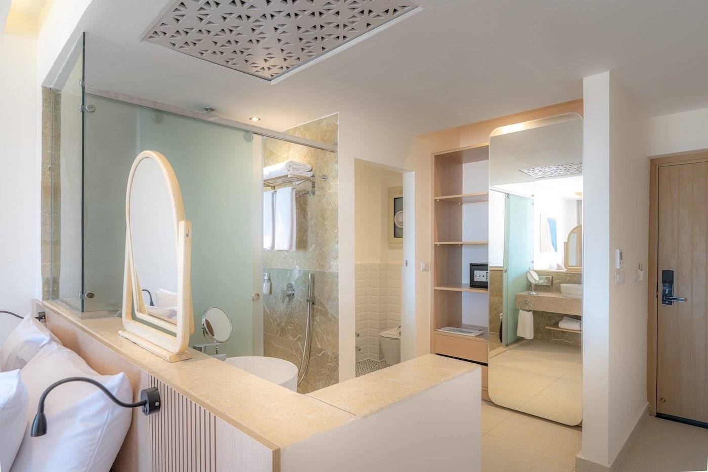 Badezimmer im Three Corners Equinox Beach Resort Hotel mit Glasdusche, Spiegel, Toilette und Waschbecken.
