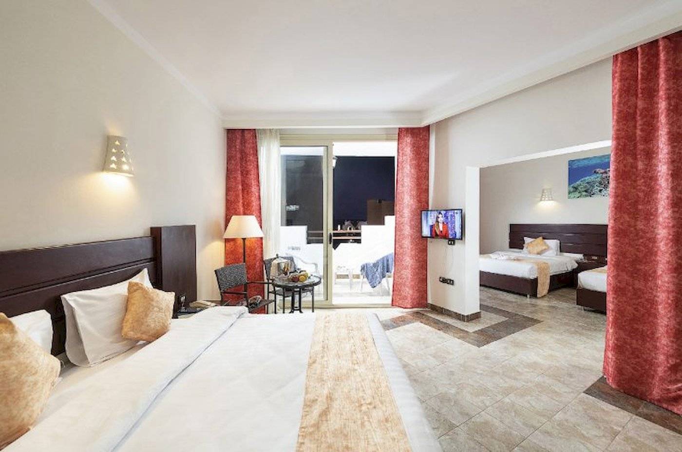 Hotelzimmer im Three Corners Equinox Beach Resort mit Doppelbett, Fernseher und Balkon