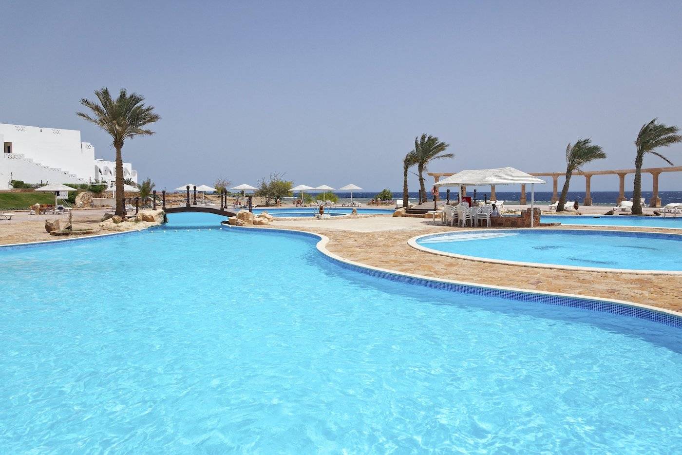 Außenpools des Three Corners Equinox Beach Resort mit Palmen und Sonnenschirmen