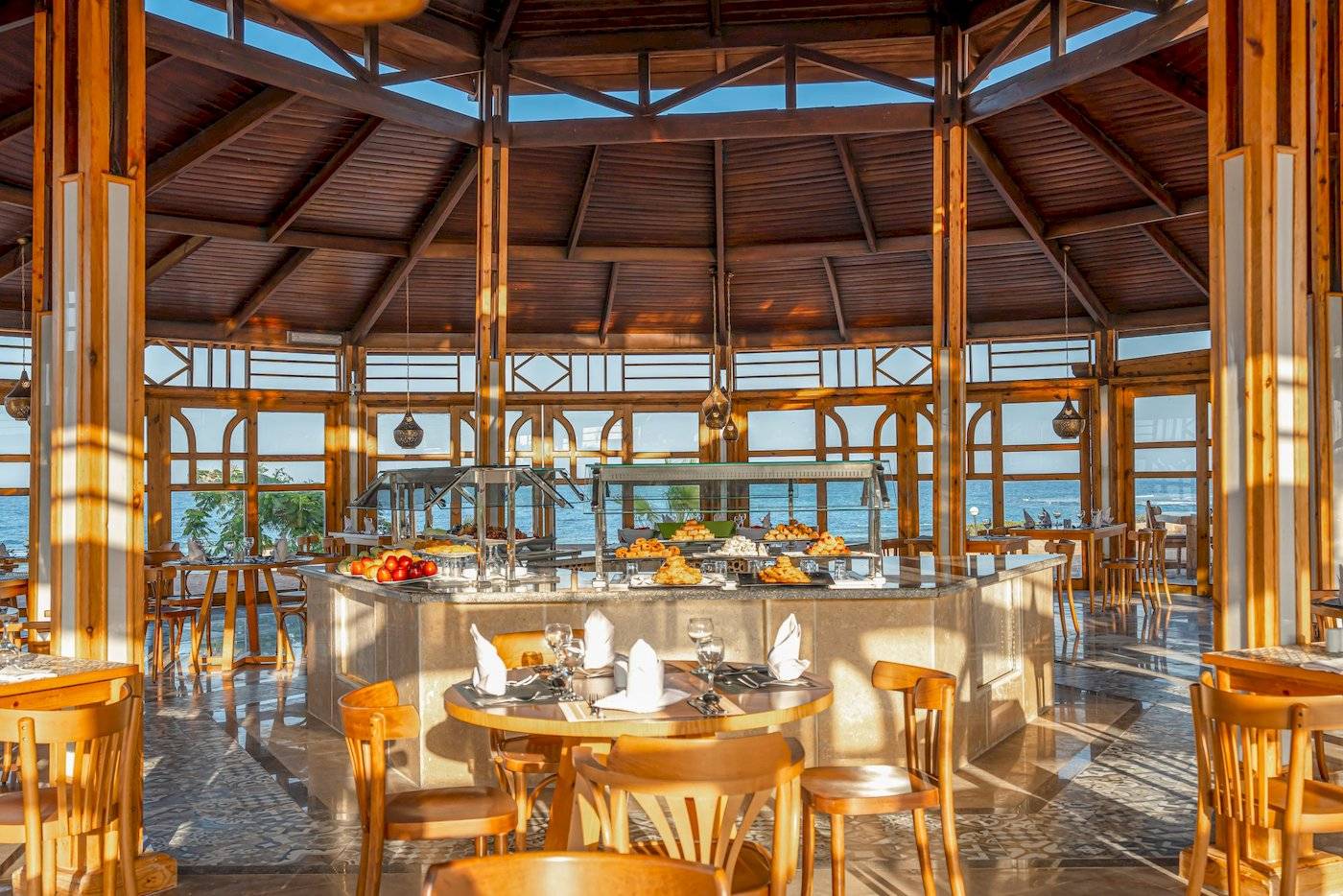 Innenansicht des Restaurants im Three Corners Equinox Beach Resort mit Buffet und Tischen.