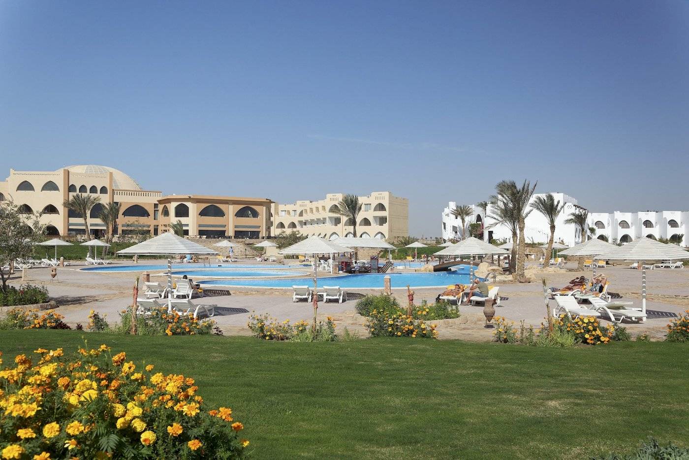 Außenbereich des Three Corners Equinox Beach Resorts mit Pool und Liegestühlen