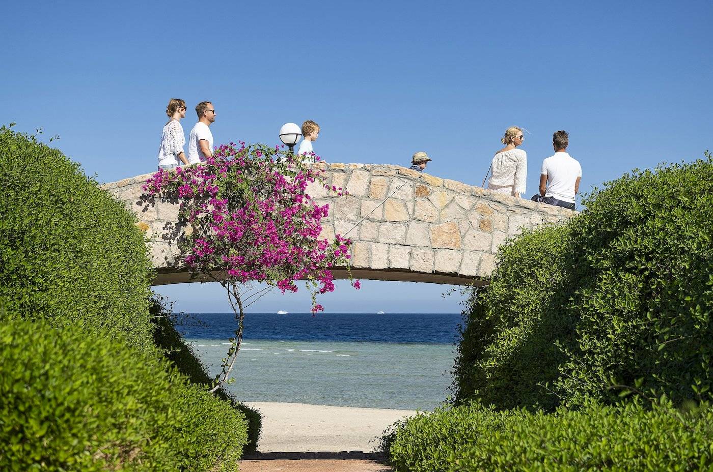 Familie auf der Brücke des Three Corners Equinox Beach Resort mit Blick auf den Strand