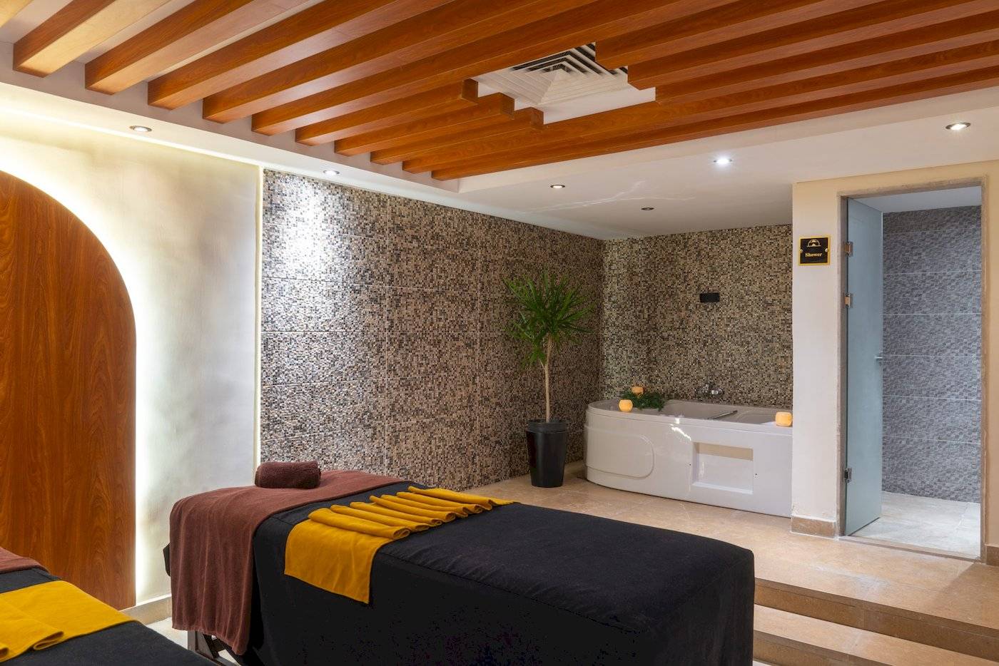 Massagebereich im Three Corners Happy Life Beach Resort mit zwei Massagebetten und einem Whirlpool.