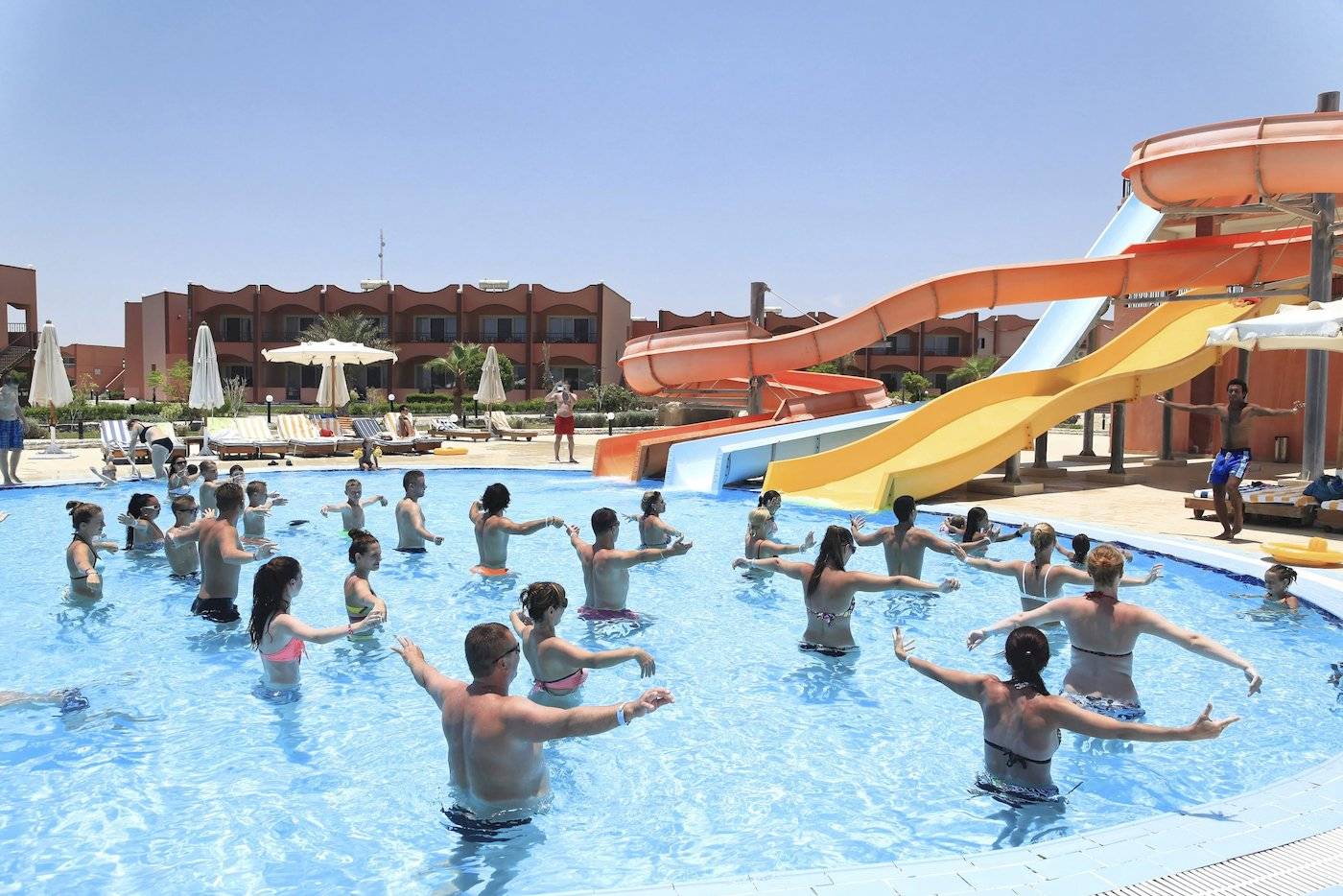 Gruppe von Erwachsenen und Kindern, die Aerobic im Swimmingpool des Three Corners Happy Life Beach Resorts machen