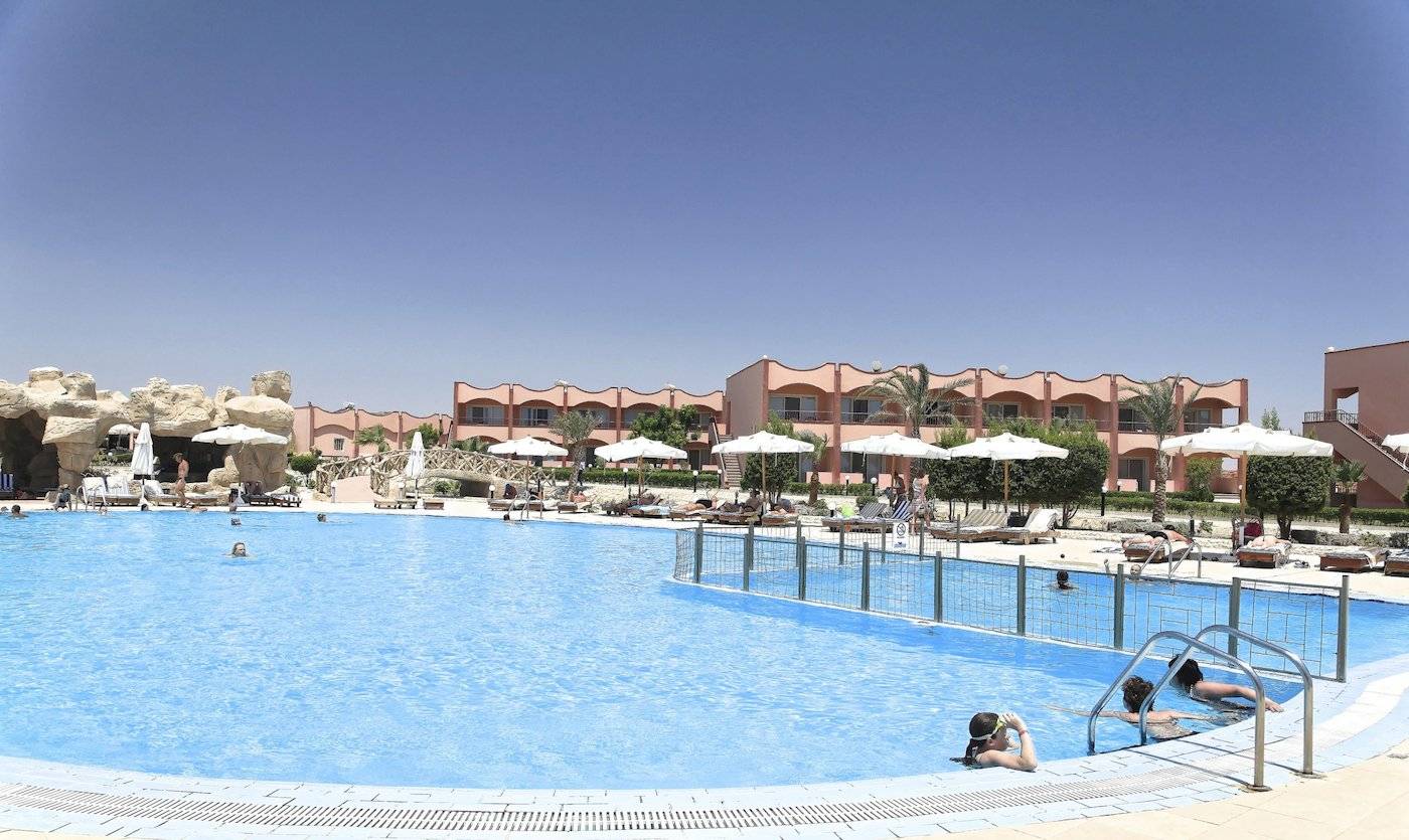 Ein Swimmingpool mit mehreren Schwimmern und Sonnenschirmen im Three Corners Happy Life Beach Resort.