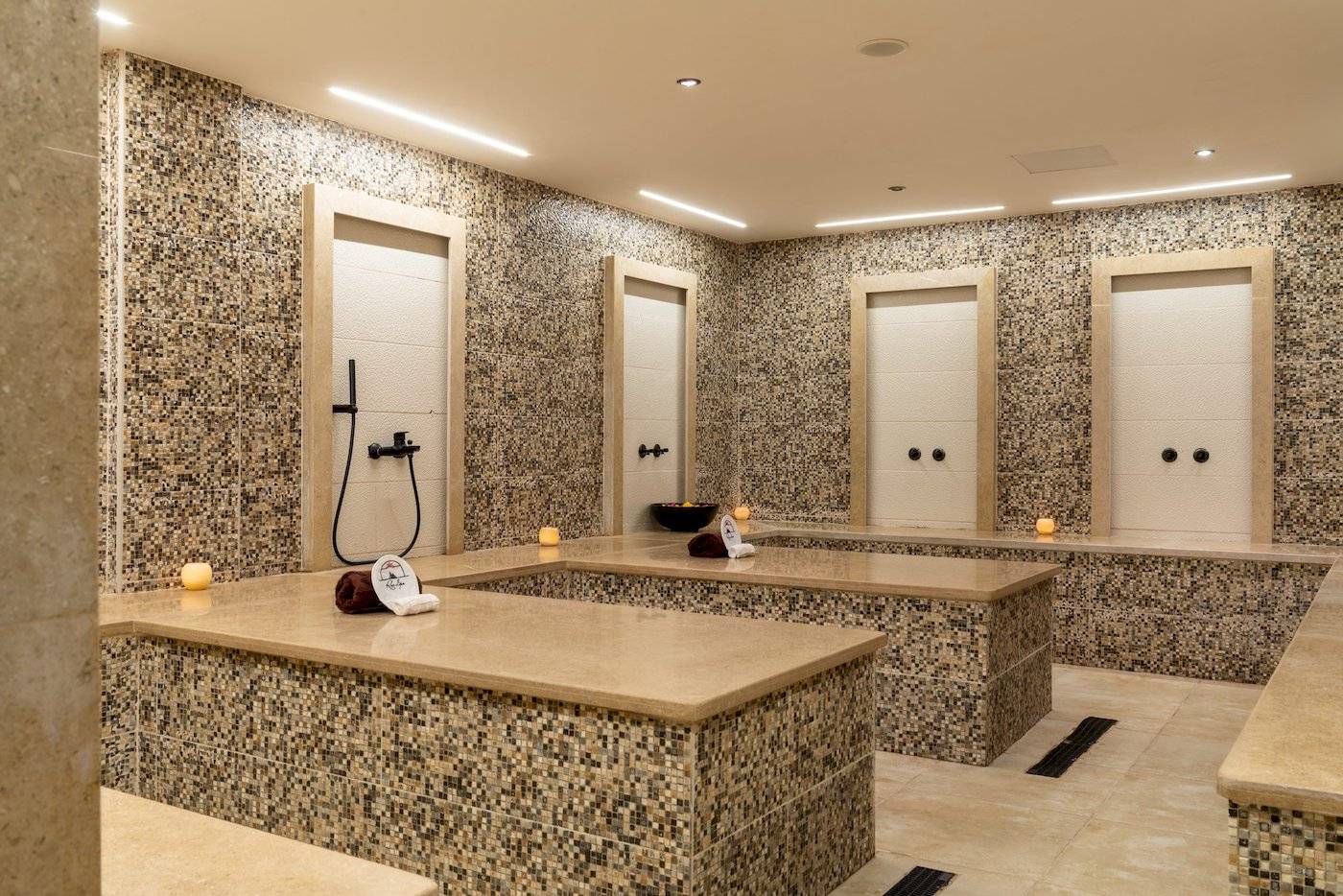 Wellnessbereich im Three Corners Happy Life Beach Resort mit mehreren begehbaren Whirlpools und beleuchteten Wänden.