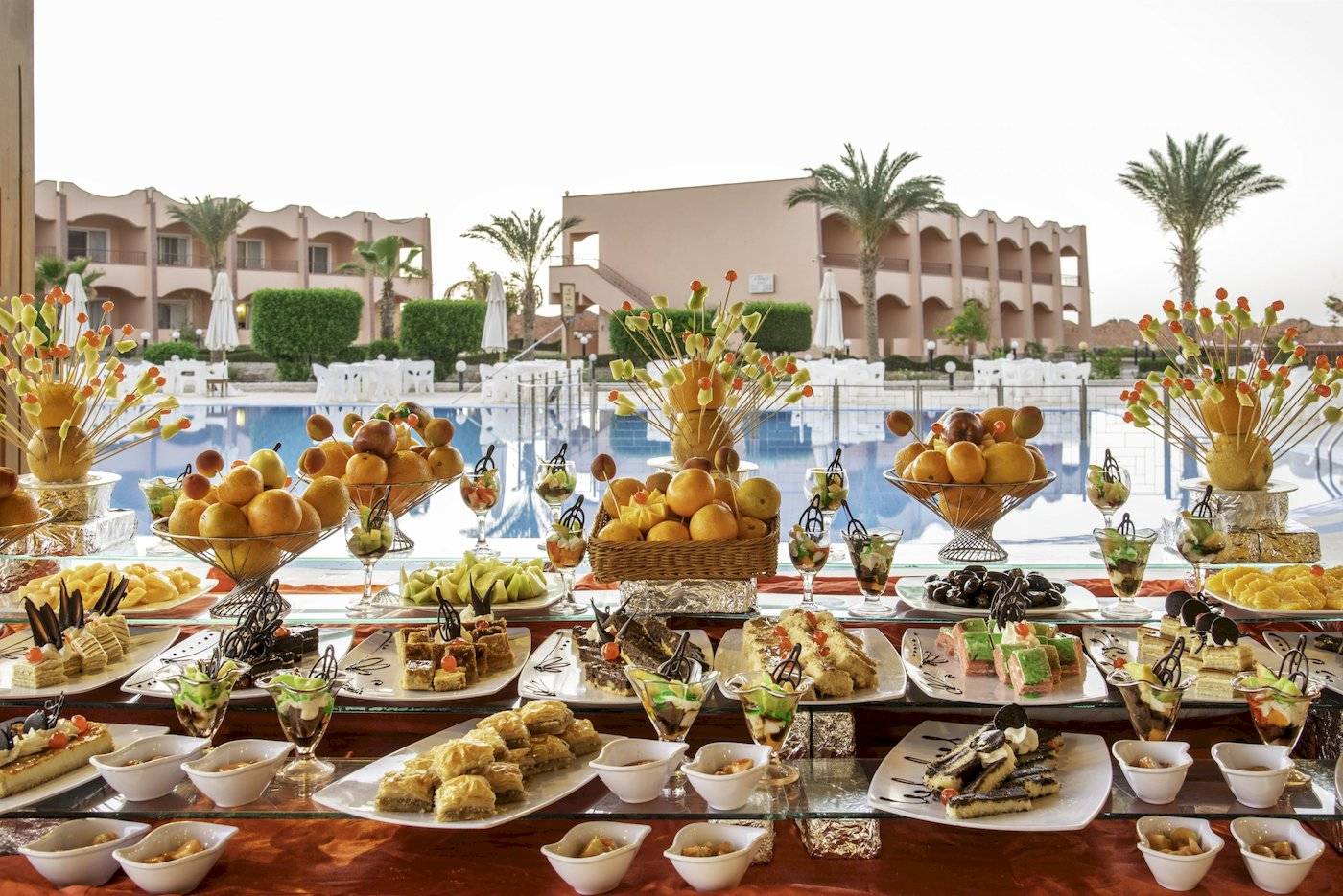 Poolseitiges Buffet mit einer Auswahl an Desserts im Three Corners Happy Life Beach Resort.