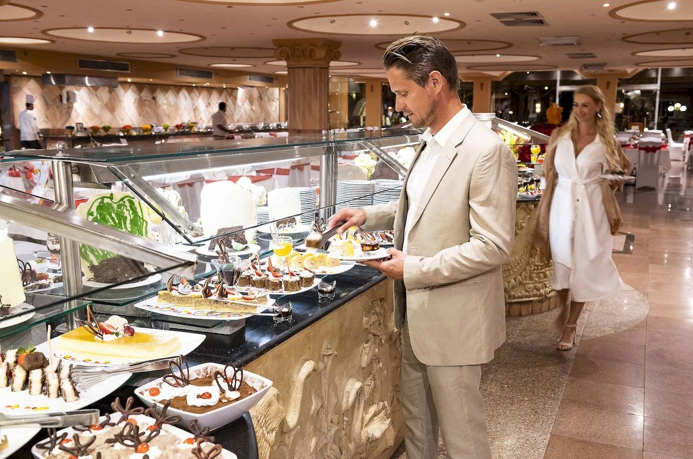 Ein Mann wählt Speisen von einem Buffet-Tisch in einem Hotelrestaurant aus.