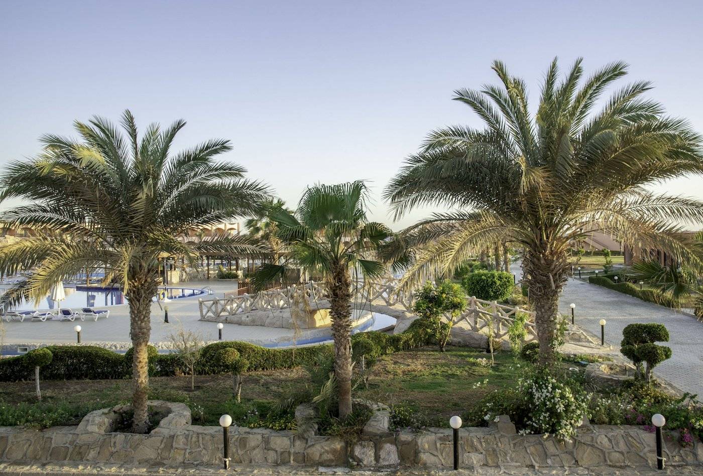 Außenbereich des Three Corners Happy Life Beach Resorts mit Palmen und einem Schwimmbad