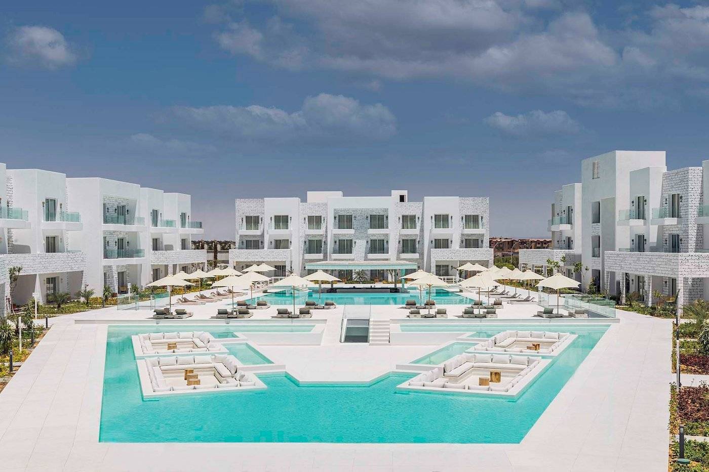 Außenbereich des Sunrise Royal Makadi Resort mit Swimmingpool und weißen Gebäuden.