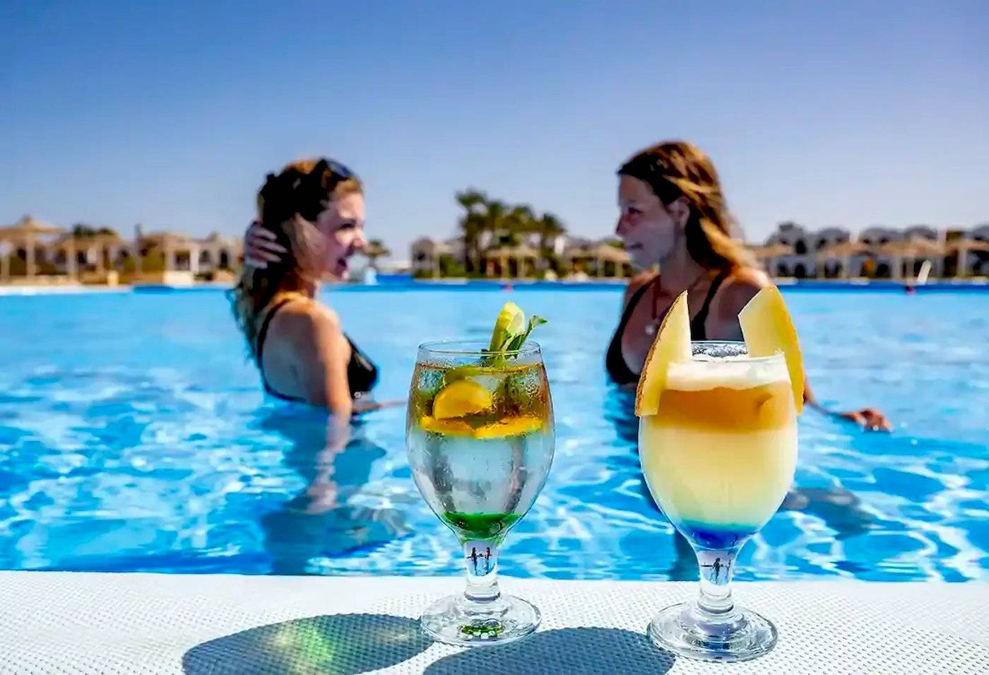 Zwei Frauen im Schwimmbad mit Getränkegläsern